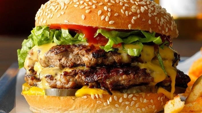 Double cheeseburger with lettuce, pickles and melted cheese at Donair and Poutine House in Edmonton, AB